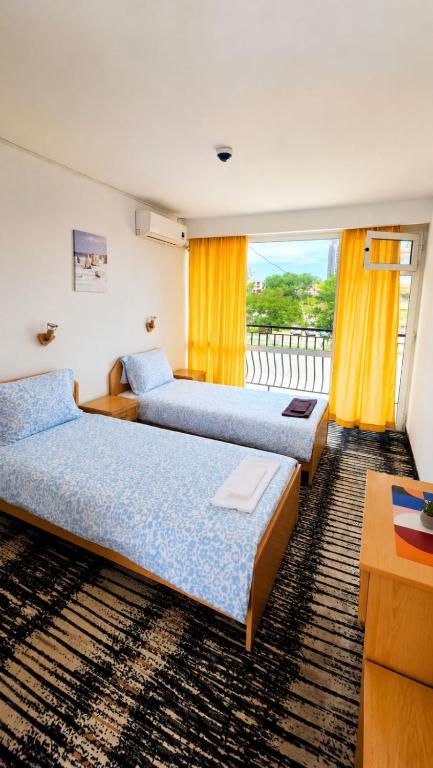 a hotel room with two beds and a window at Sunny Steps Hostel in Sunny Beach
