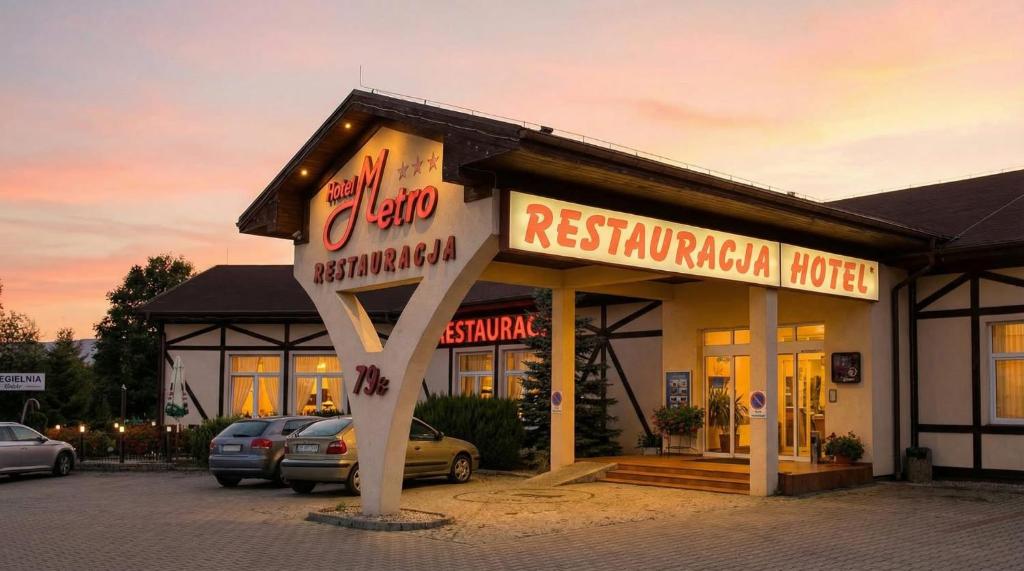 a restaurant with a sign in front of a building at Hotel Metro in Kłodzko