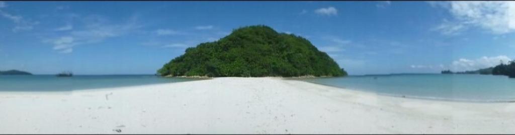 a small island in the middle of the ocean at Kelambu Beach Villa in Kudat