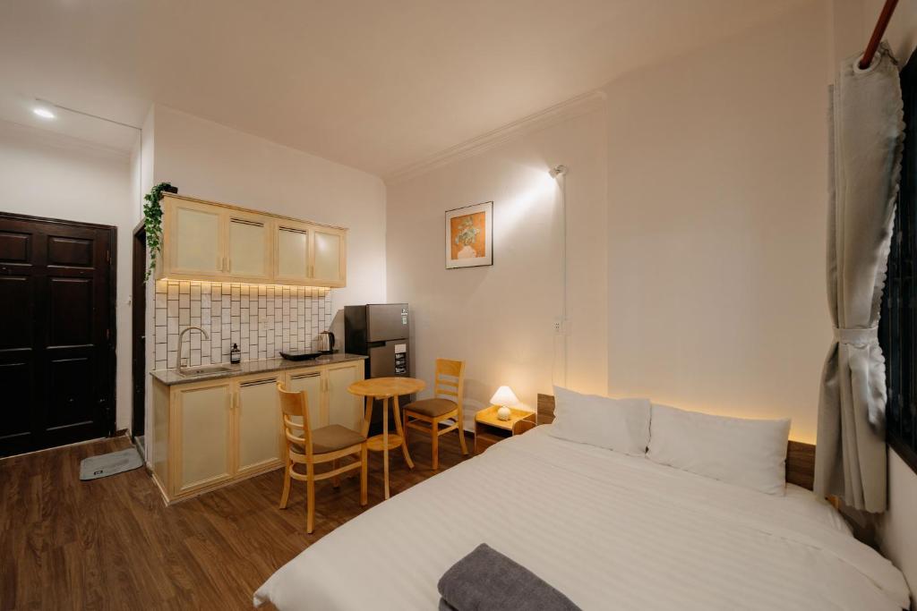 a bedroom with a bed and a small kitchen at Exia House in Ho Chi Minh City