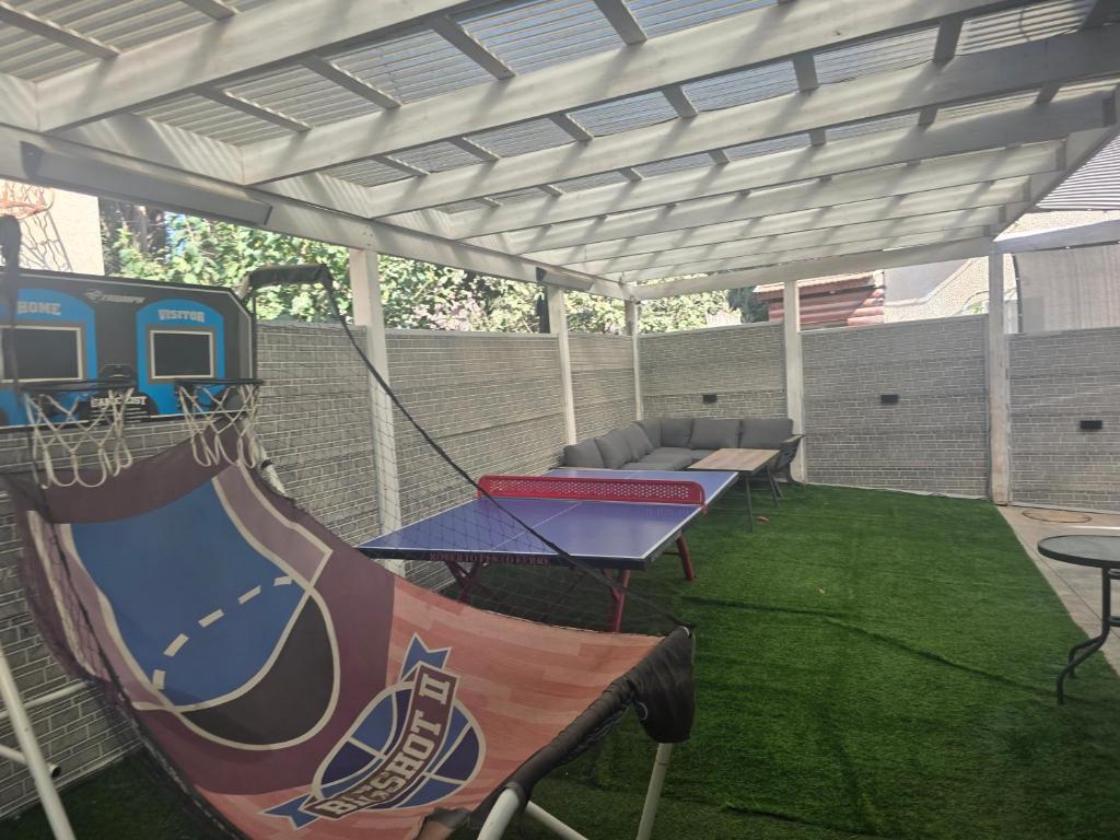 a covered patio with a table and a swing at אחוזת ישי-אברהם in Tiberias