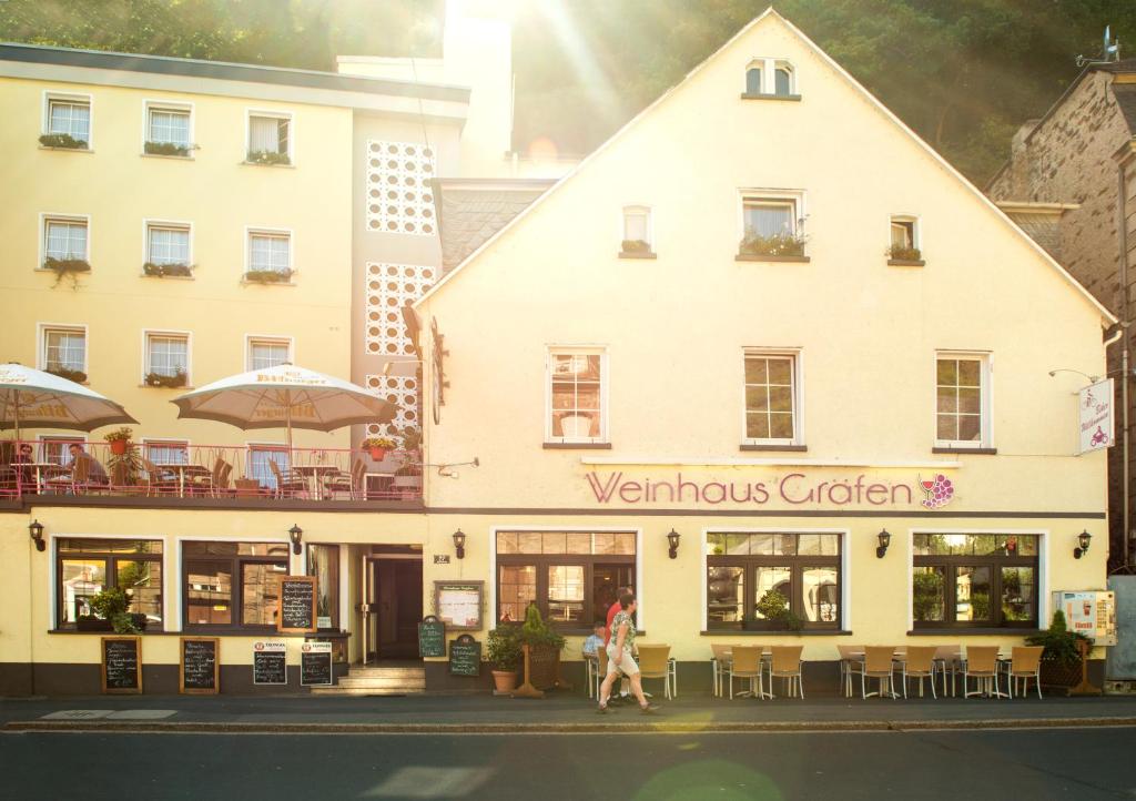 a building with a woman walking in front of it at Weinhaus Gräfen in Cochem