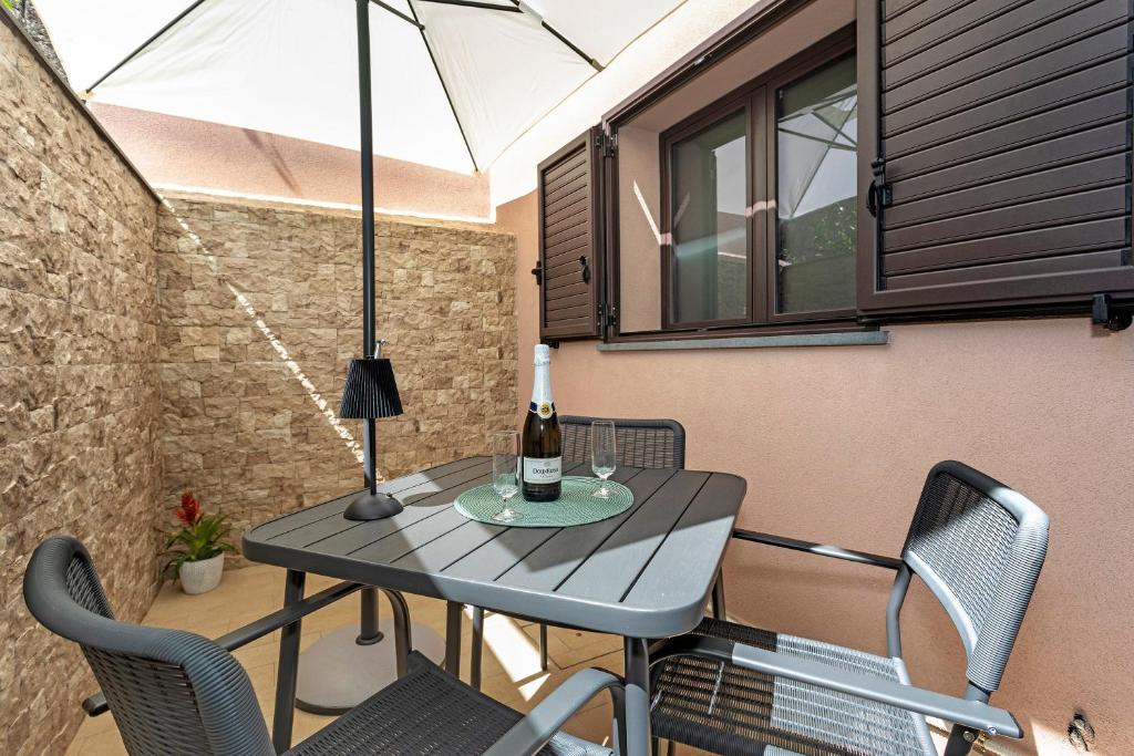 a table with a bottle of wine on a patio at Perla Dell'Etna Holiday House in Zafferana Etnea