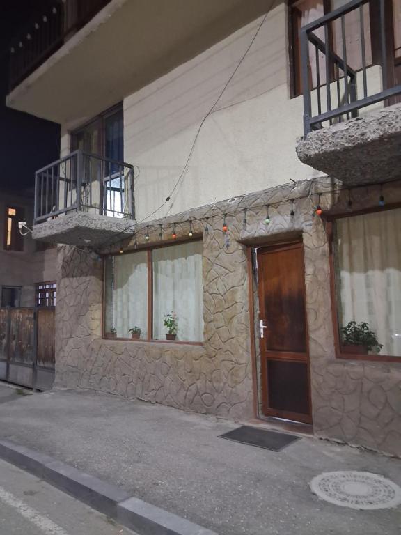 a stone building with two balconies and a door at Lama inn in Mestia