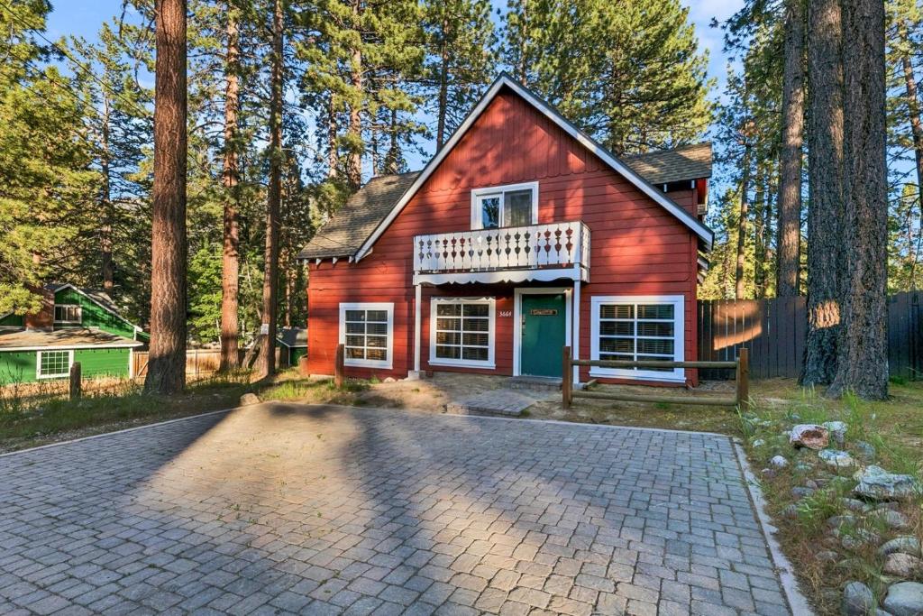 a red house in the woods with a driveway at 3664 Birch Avenue cabin in South Lake Tahoe