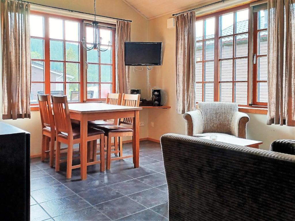 a dining room with a table and chairs and windows at Cozy Cabin with Fireplace in Åre