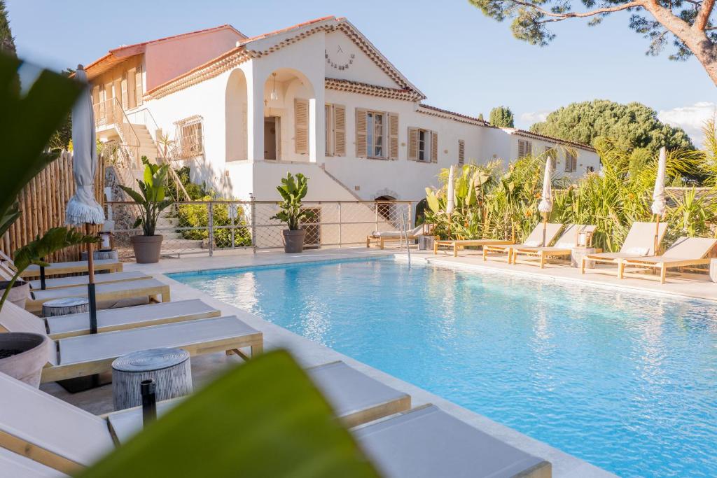 a swimming pool in front of a house at Auberge TAO in Biot