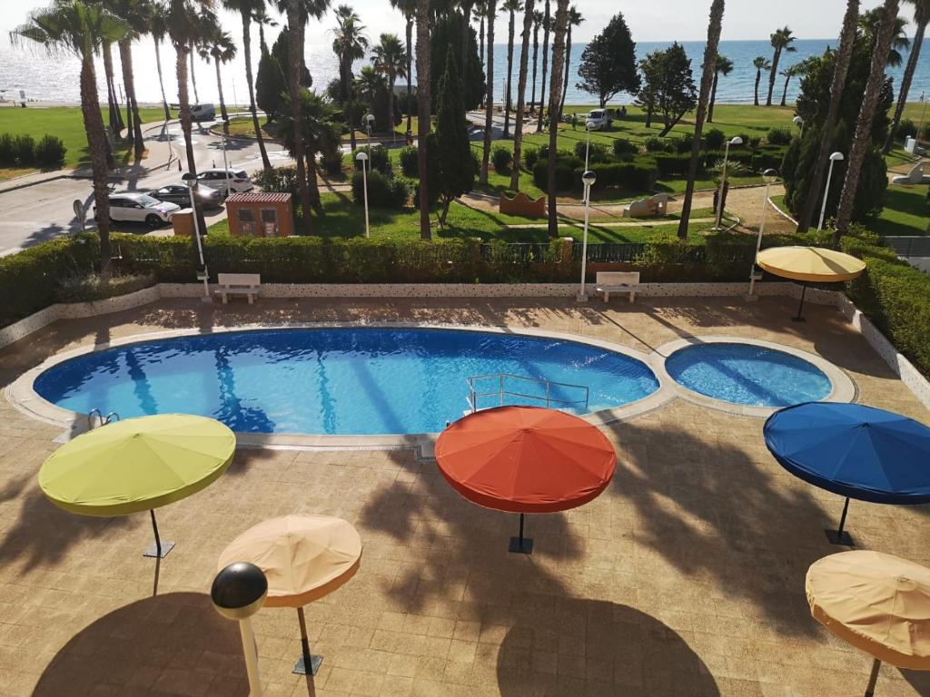 an overhead view of umbrellas in front of a pool at Vistamar -primera linea de playa in El Borseral