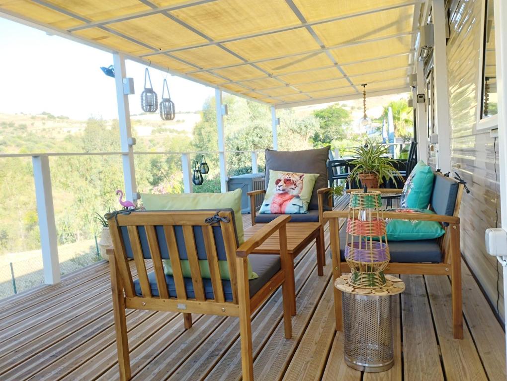a porch with two benches and a table and chairs at The Hillside Lodge in Pizarra