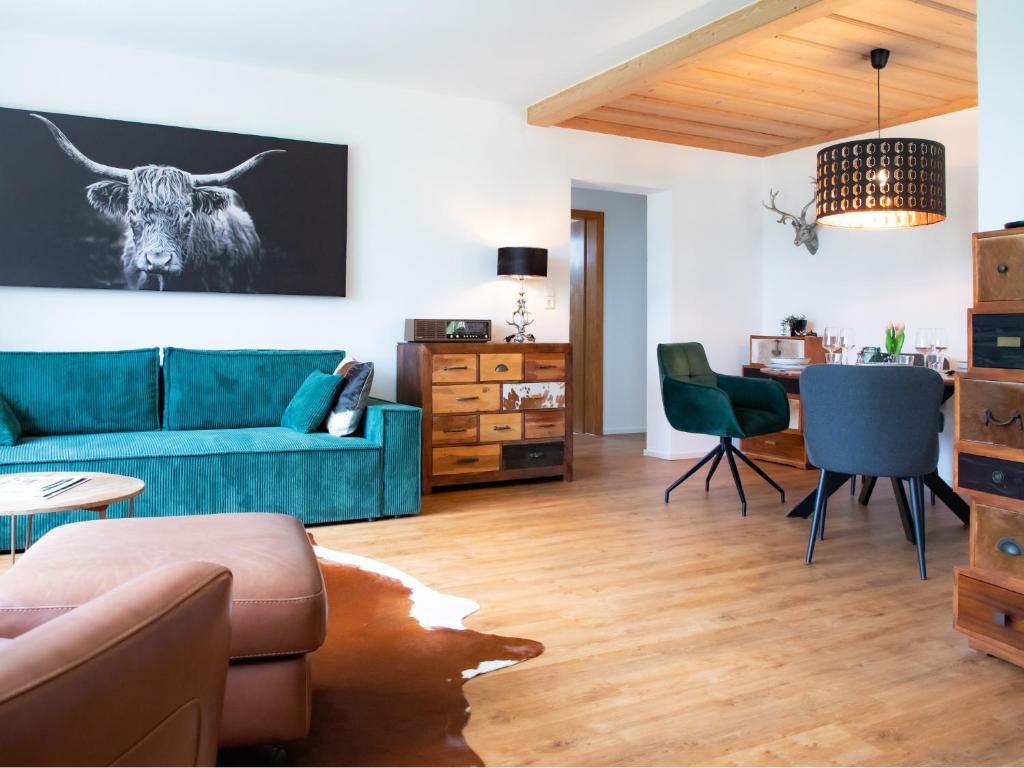 a living room with a blue couch and a table at Allgäu Bungalow GLOW in Isny im Allgäu