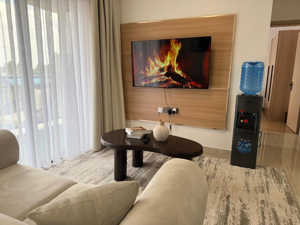 a living room with a couch and a table with a fireplace at Rama Stays in Nairobi