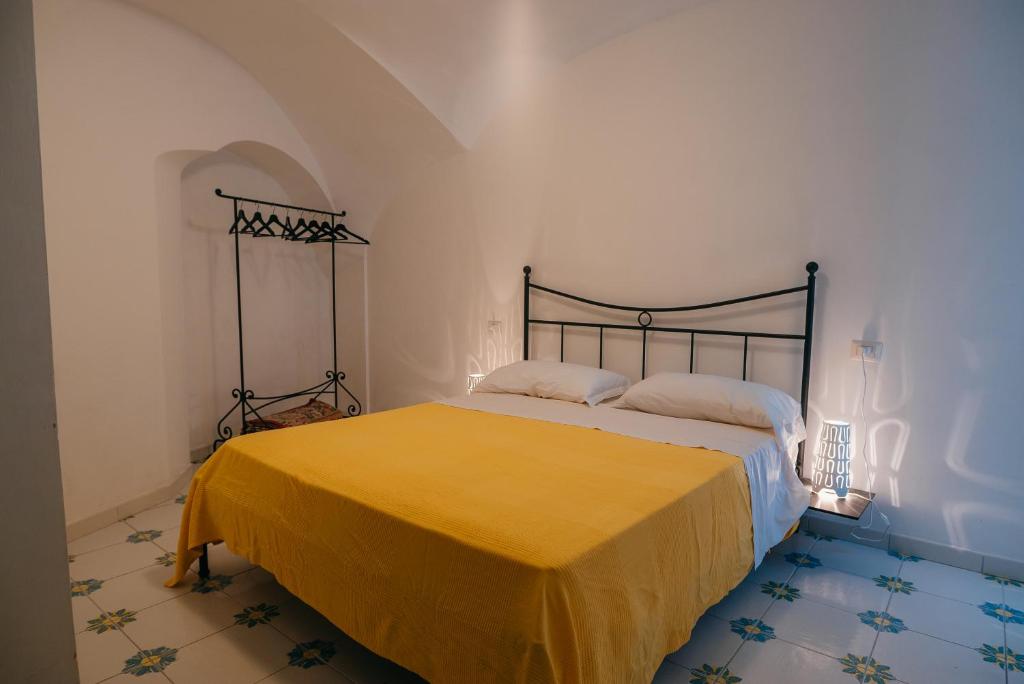 a bedroom with a bed with a yellow blanket at Casetta Puntino in Atrani