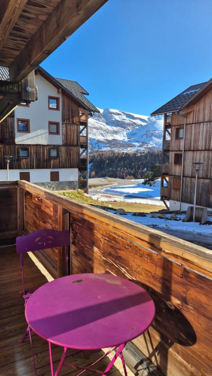 a purple chair sitting on a deck with a table at Le Chalet de Super D in Le Dévoluy