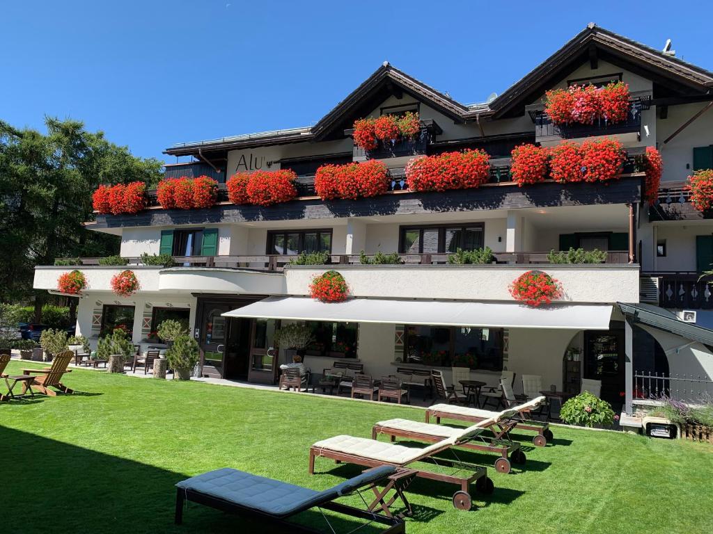ein Gebäude mit Tischen und Stühlen in einem Hof in der Unterkunft Hotel Alù Mountain Design in Bormio