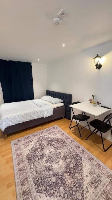 a bedroom with a bed and a table and a rug at Modern Mini Apartment in Malmö