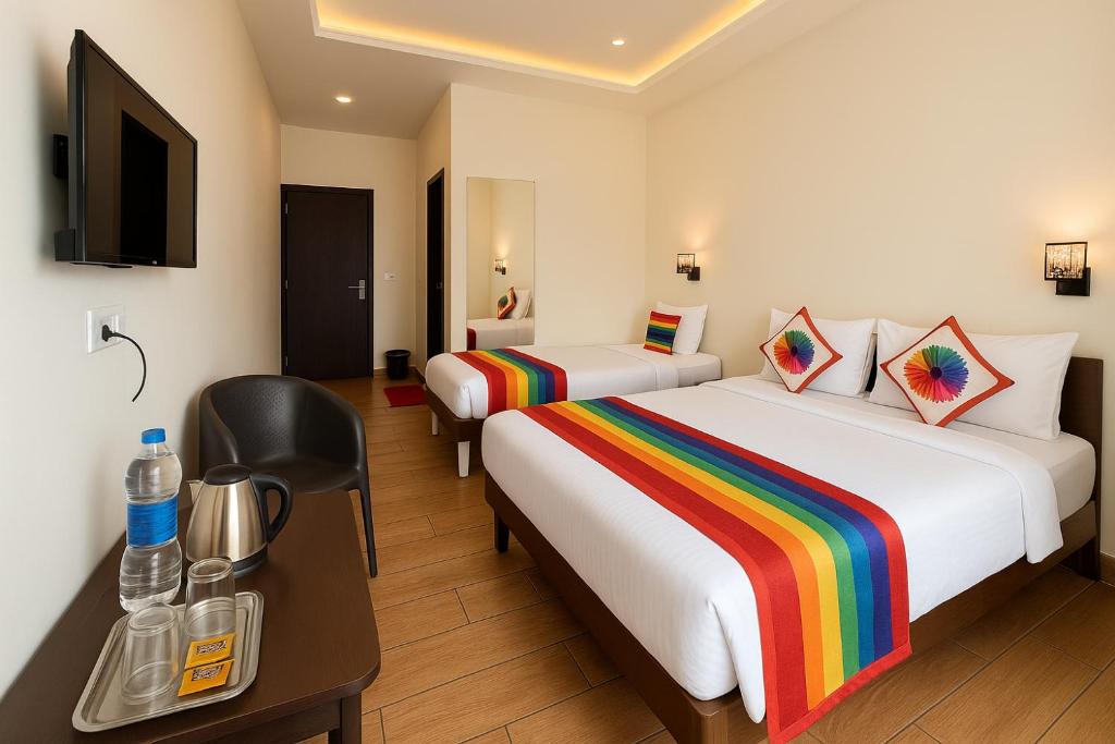 a hotel room with two beds and a television at Hotel Lake Star Bistro in Udaipur