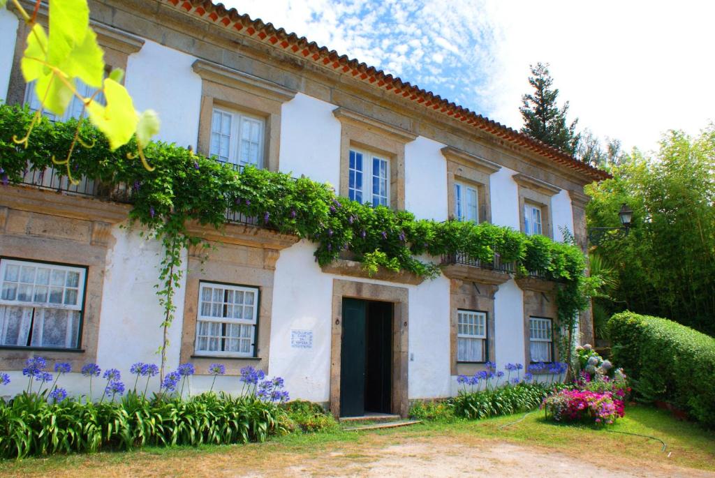 an old house with flowers in front of it at Casa da Várzea in Beiral do Lima