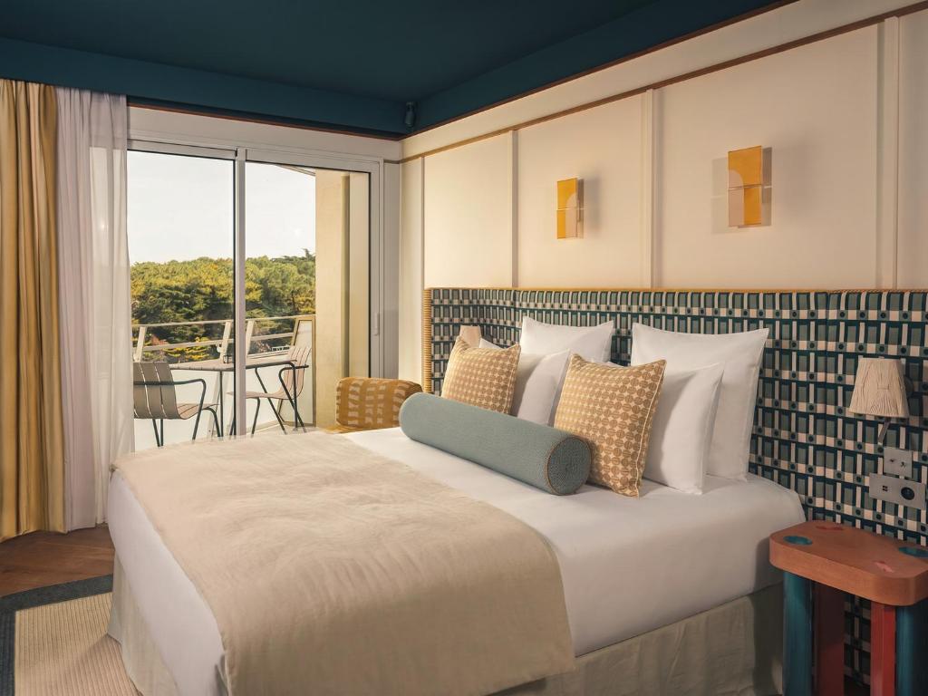 a bedroom with a large bed and a balcony at Les Cimes Bleues in La Baule