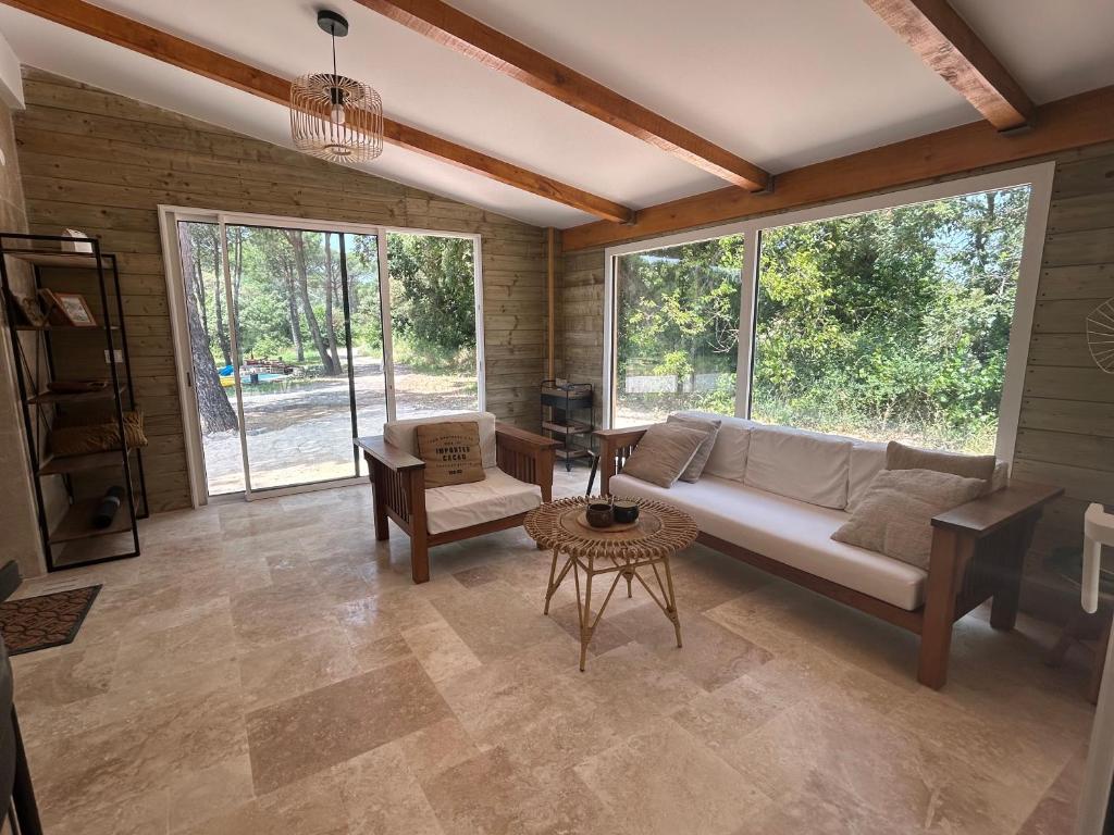 a living room with a couch and a table at Maison récente dans la nature in Roquebrune-sur-Argens