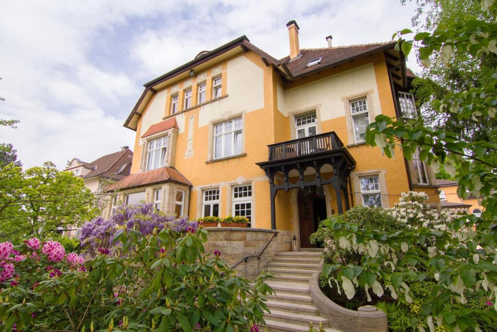 een geel huis met bloemen ervoor bij Gästehaus Musmann in Hannoversch Münden