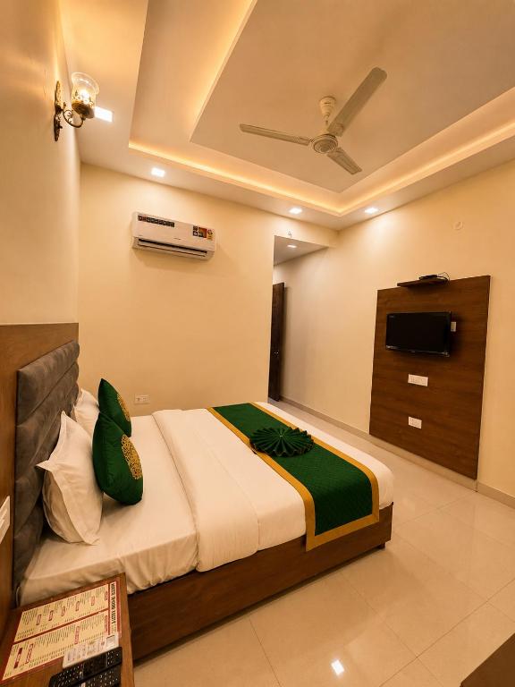 a bedroom with a bed and a television in a room at Hotel Woodlark Heights Zirakpur Chandigarh !! Family Hotel ! Easy Airport Access ! Budget Friendly in Chandīgarh