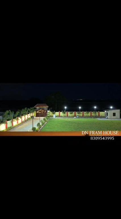 a view of a park at night with a building at Dn FARM HOUSE in Moinabad