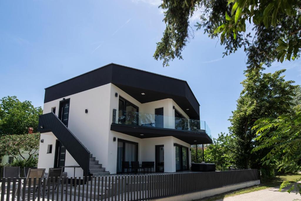 a white house with a black roof at Vila Dominus Lux in Veliko Gradište