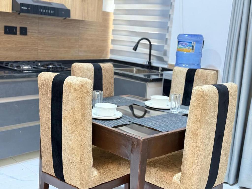 a table with chairs and a sink in a kitchen at Esthella Property in Ijaiye