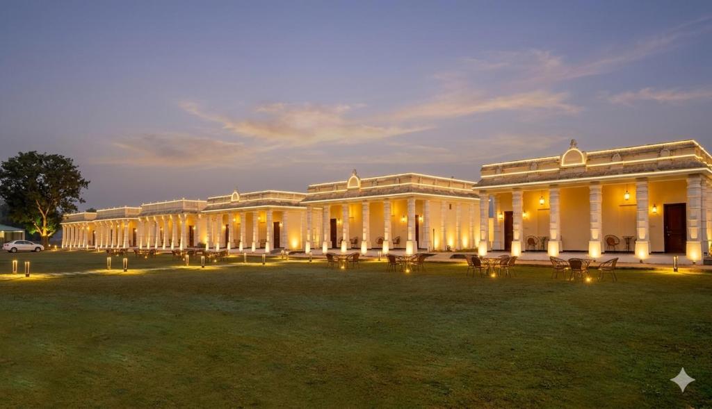 a large building with a lawn in front of it at Aaram Baagh Maheshwar in Maheshwar