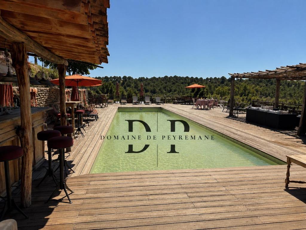 a swimming pool with a sign on a wooden deck at Suite piscine in Valensole
