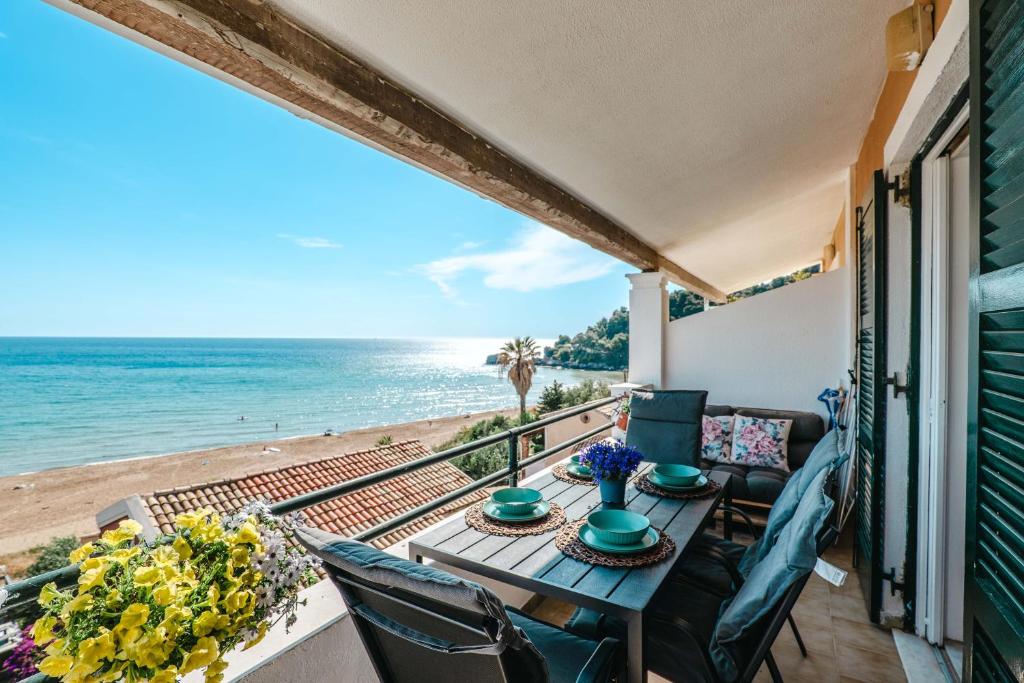 a balcony with a table and chairs and the beach at Corfu Dream Holidays Villas in Glyfada