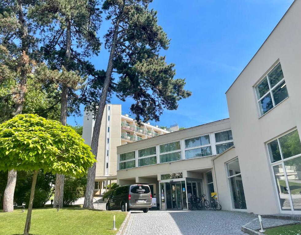 a white building with a car parked in front of it at Kurzentrum Ludwigstorff GmbH in Deutsch Altenburg