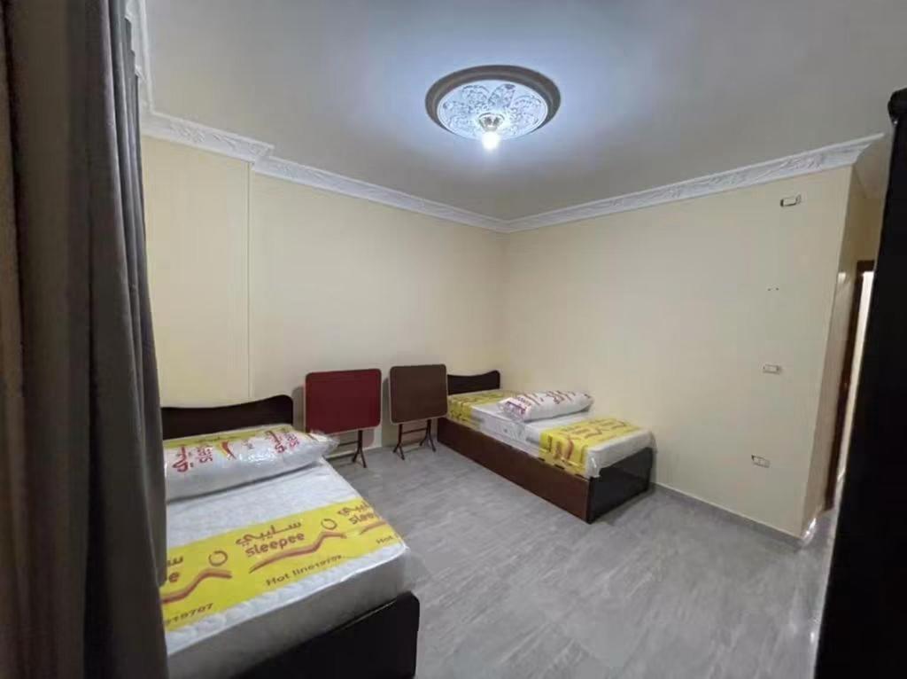 a room with two beds and two chairs in it at Newytr home in Kafr al Ishārah