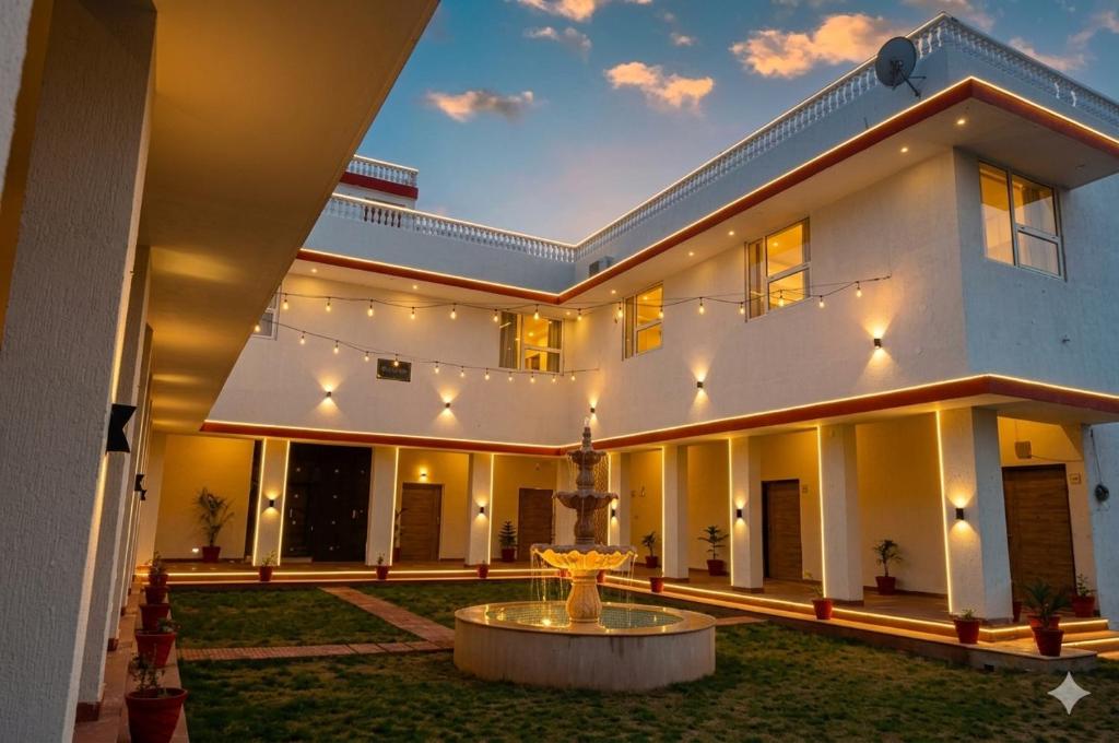 a large white building with a fountain in the yard at The Vanashva in Tehla