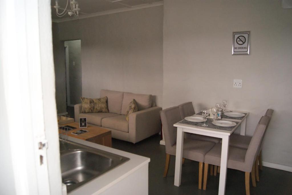 a kitchen and living room with a table and a couch at Chalet Duiker in Ladismith