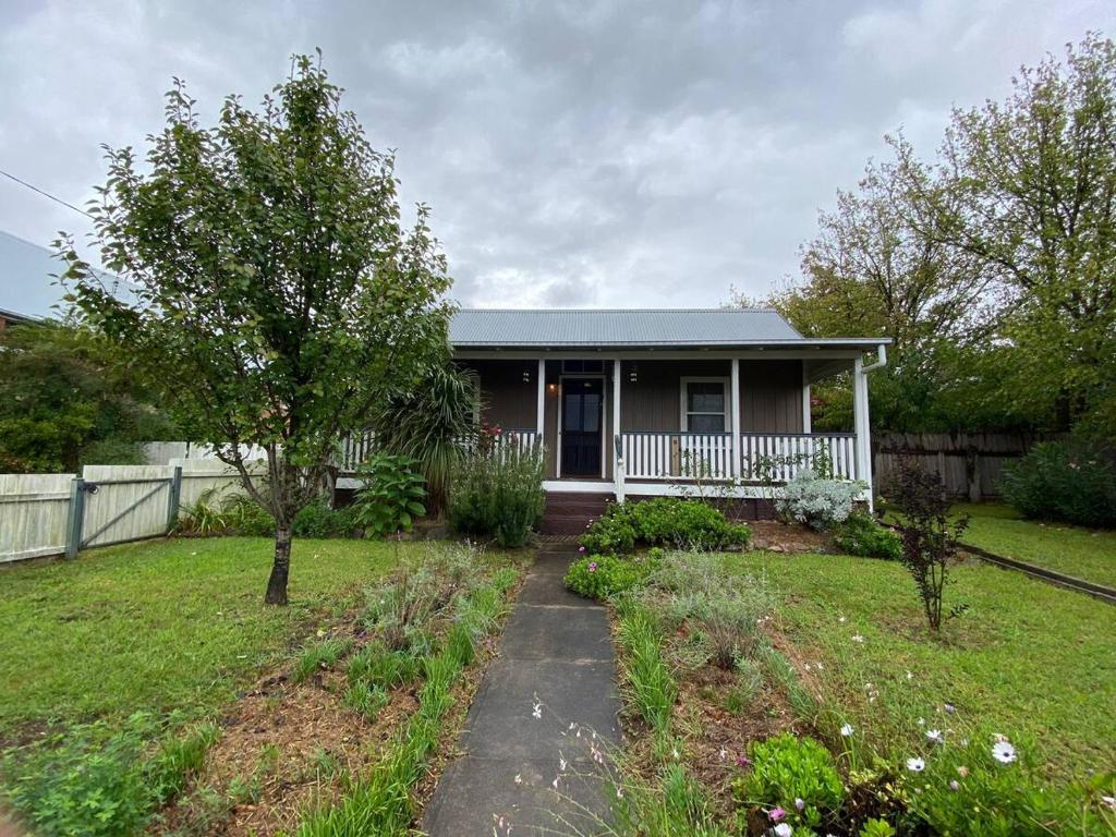 a small house with a porch and a yard at Awen Cottage in Tenterfield