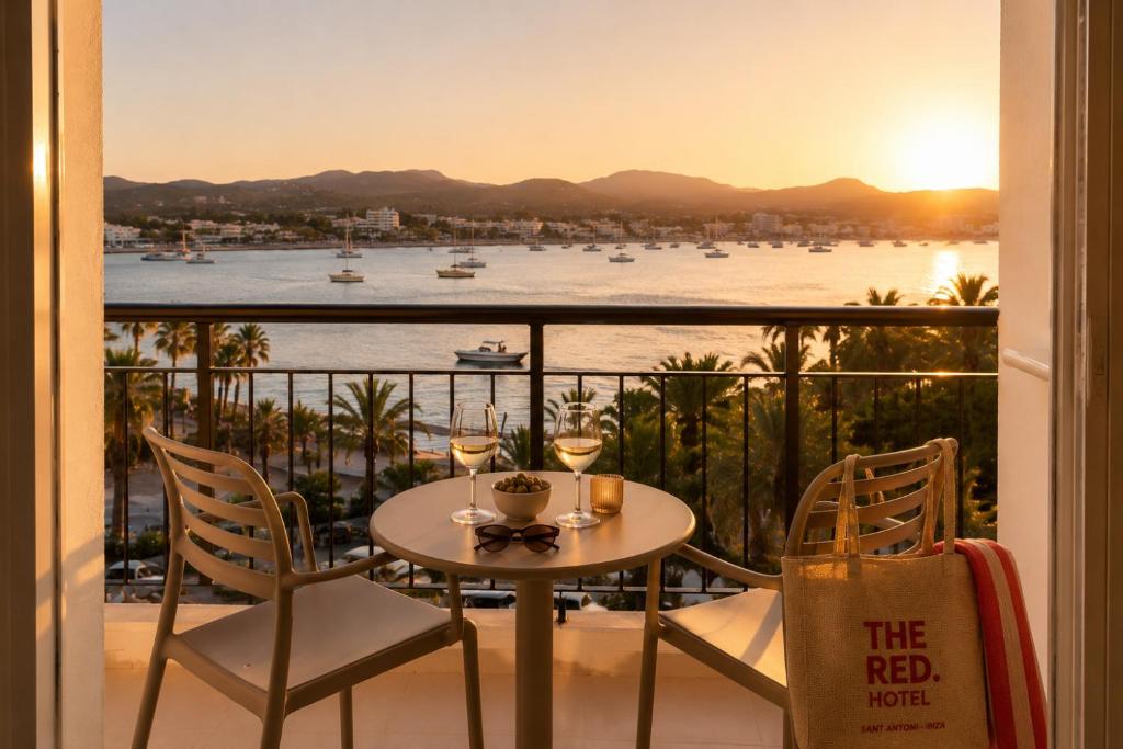 a table and chairs on a balcony with a view of the water at The Red Hotel - Adults Only in San Antonio