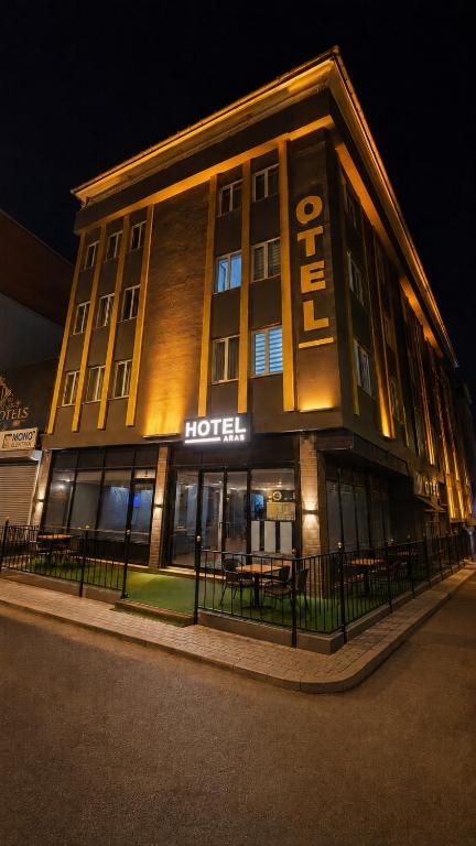 a hotel building with a lit up sign at night at Çorlu Aras Hotel & City Center Location in Çorlu