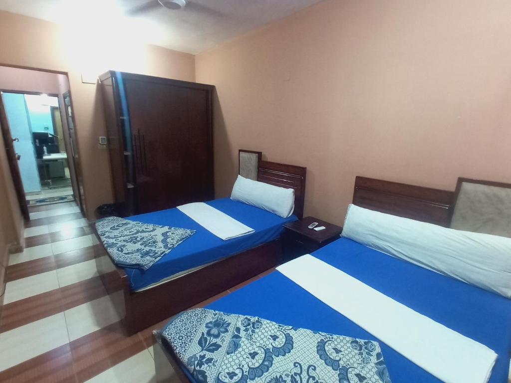 two beds in a room with blue and white sheets at Aswan City Center Guest House in Aswan