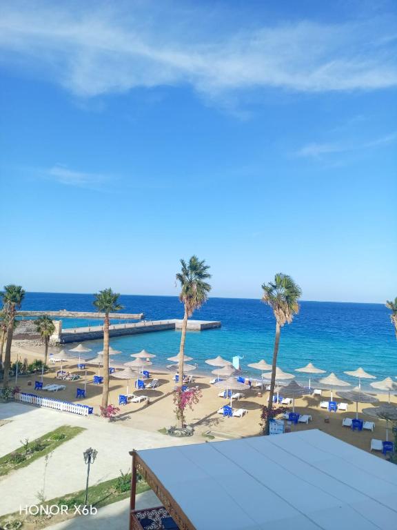 a view of a beach with palm trees and umbrellas at Juliana Beach Hurghada in Hurghada