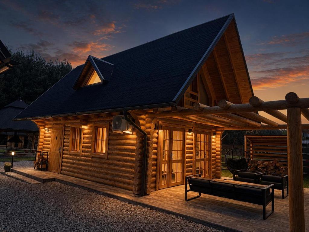a log cabin with a bench in front of it at Balujemy w Radawie in Radawa