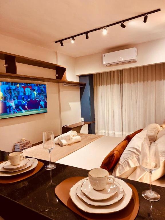 a bedroom with a bed with plates and wine glasses at Desing Studio, luxo e Moderno Vila Velha-ES in Vila Velha