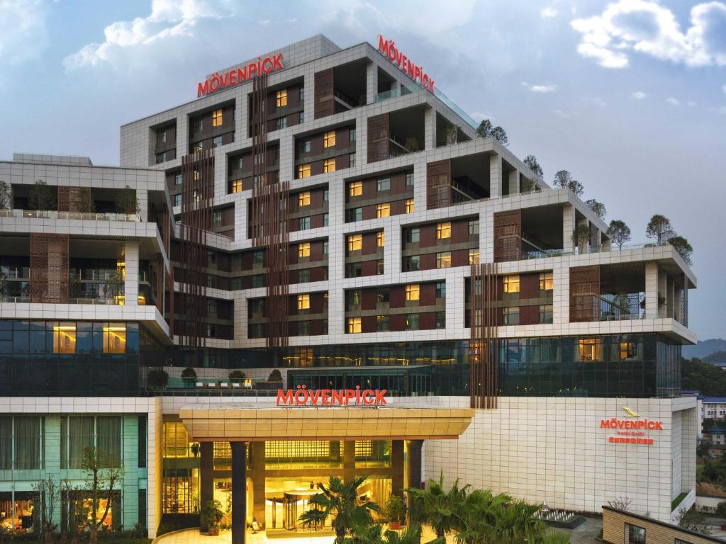 a large building with a red sign on it at Movenpick Hotel Enshi in Enshi