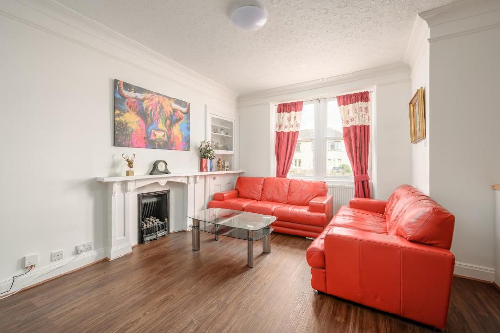 a living room with a red couch and a fireplace at Bosta Guest House - Private Rooms - Inverness in Inverness