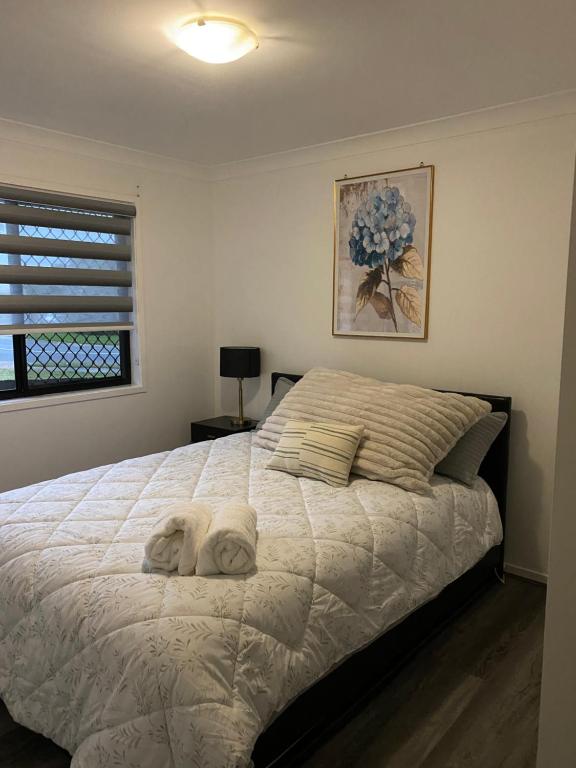 a bedroom with a large bed with towels on it at Casa Bliss in Springfield Lakes