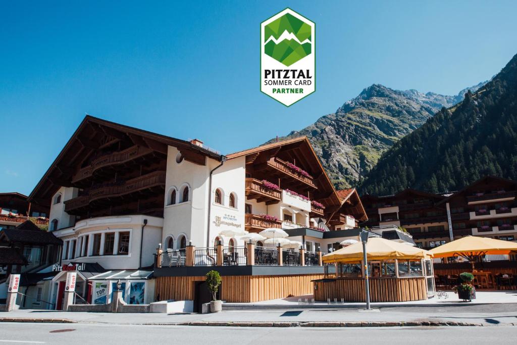 a large building in front of a mountain at Hotel Mittagskogel Pitztal in Sankt Leonhard im Pitztal
