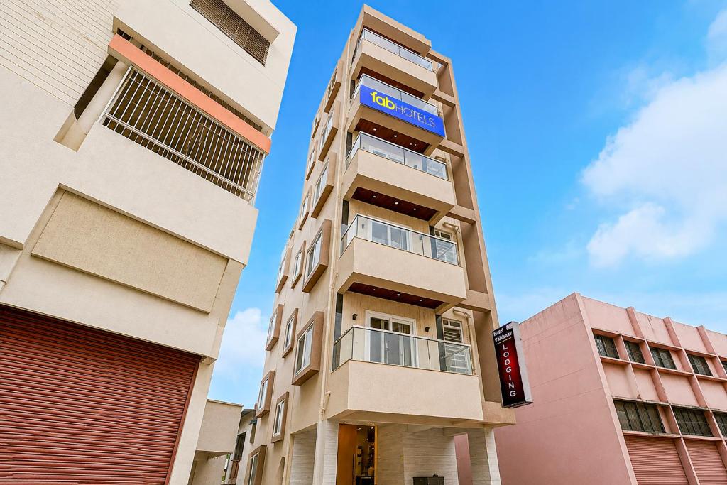 a tall apartment building with a blue sign on it at FabHotel Vaishnav Bairagi in Nashik