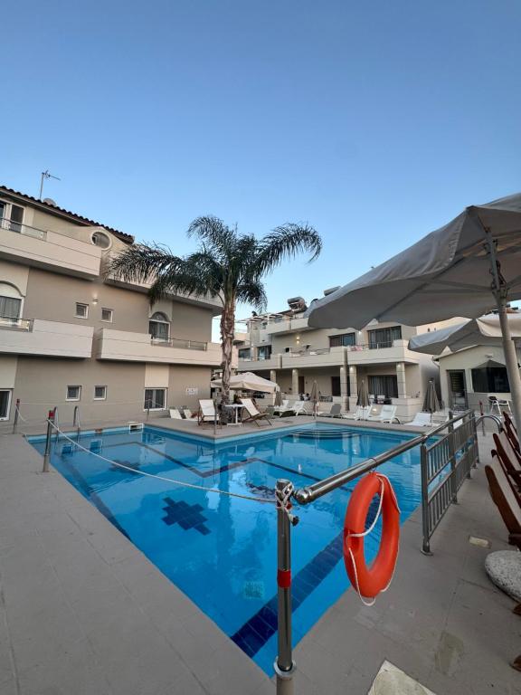a large swimming pool in front of a hotel at Sirena Apartments in Agia Pelagia