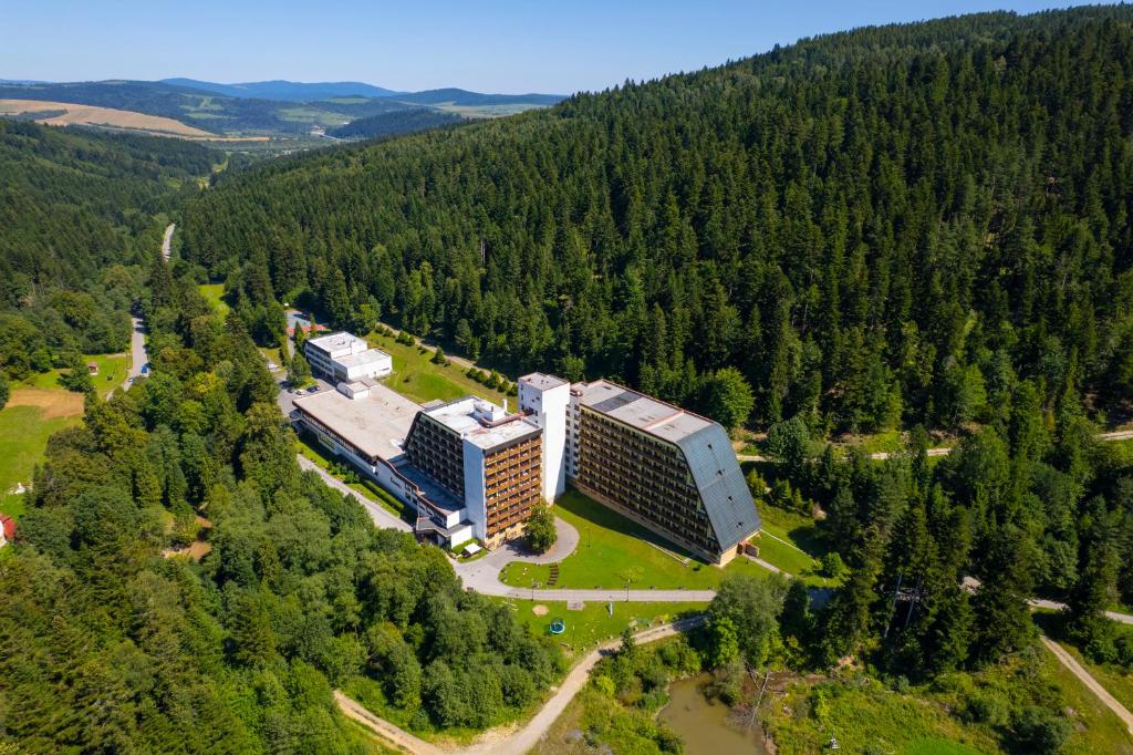 an aerial view of a building in the middle of a forest at Hotel SOREA ĽUBOVŇA in Stará Ľubovňa