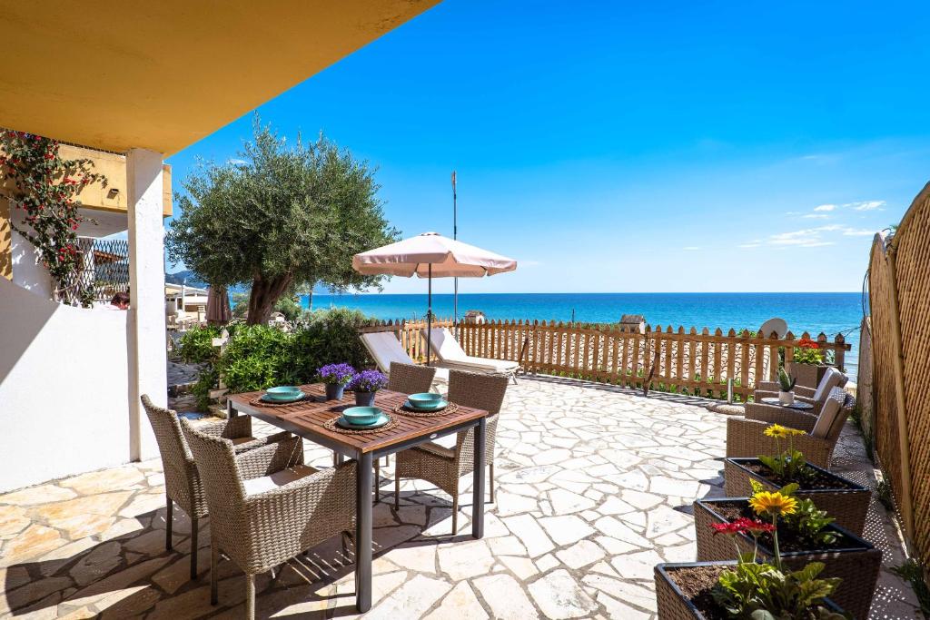 a patio with a table and chairs and the ocean at Corfu Dream Holidays Villas in Glyfada